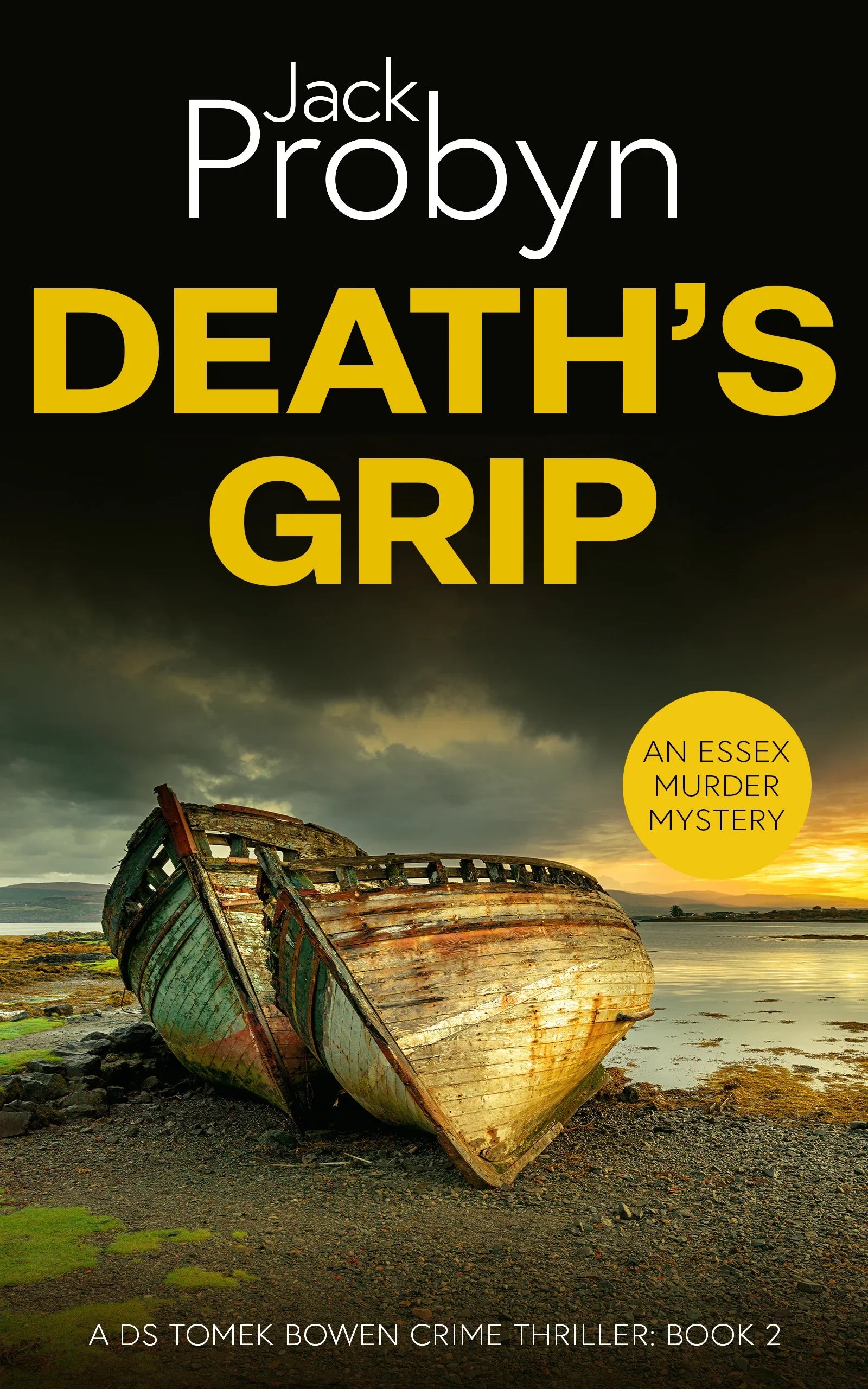 Book cover of Death’s Grip, an Essex Murder Mystery by Jack Probyn. A gritty crime thriller featuring two decaying, rusted boat hulls abandoned on a rocky shoreline at sunset. Book 2 in the DS Tomek Bowen series, perfect for fans of JD Kirk and JM Dalgliesh