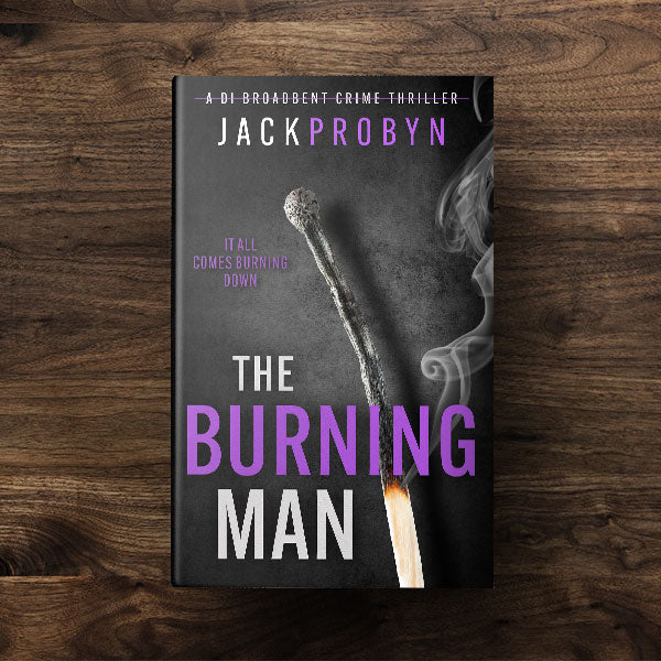 Book cover for The Burning Man, a DI Broadbent crime thriller by Jack Probyn. The cover depicts a single, long matchstick that has been partially burned, with a small flame at the bottom and wisps of grey smoke rising against a dark, slate-grey background